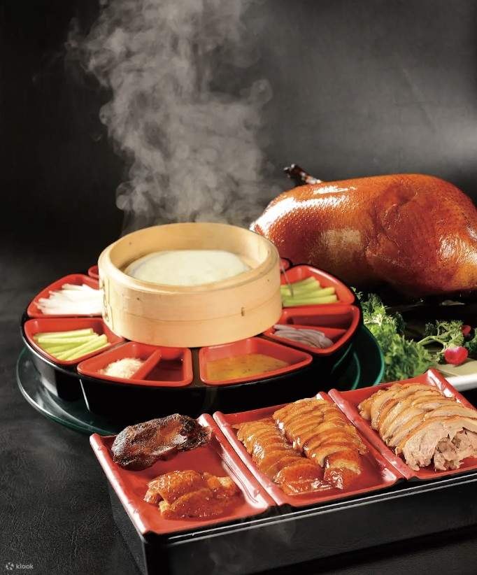 A Beijing dinner spread with roasted duck and a steaming pot